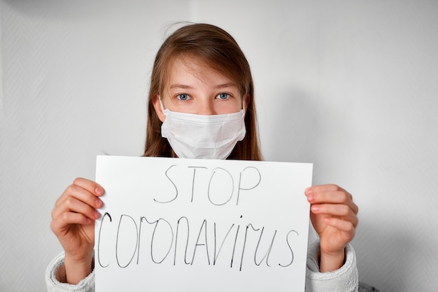 O perigo de uma epidemia mundial de coronavírus um retrato de uma garota com um pôster na mão cuidados de saúde