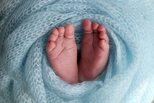 Foto o pezinho de um bebê recém-nascido pés macios de um recém-nascido em um cobertor de lã azul close dos dedos dos pés, calcanhares e pés de um recém-nascido fotografia macro