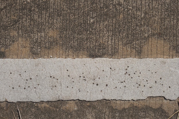 O piso de cimento tem rachaduras e padrões