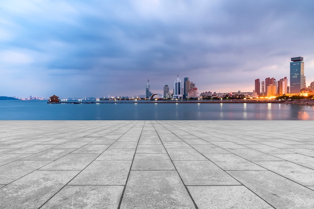 O piso de mármore vazio e o horizonte dos prédios urbanos de qingdao.