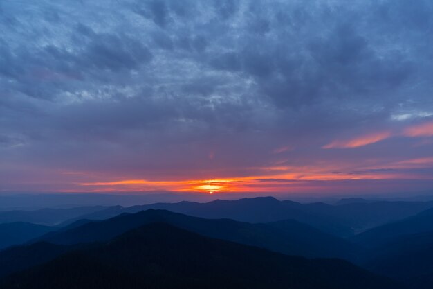 O pitoresco pôr do sol sobre a paisagem montanhosa