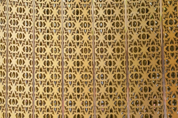 O pop-up de padrão tailandês de artesanato dourado no pano de fundo da parede em algum lugar na Tailândia