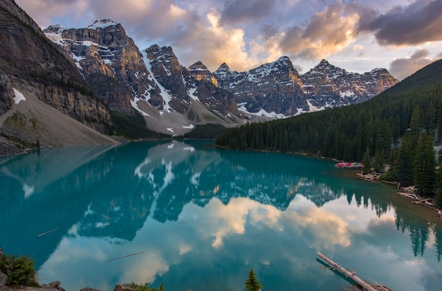 O pôr do sol do Lago Moraine com neve com lago turquesa e céu nublado por do sol