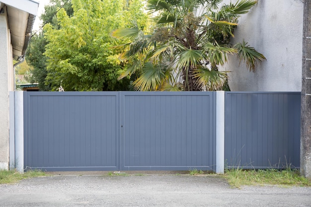 O portão cinza e a pequena porta da casa isolada