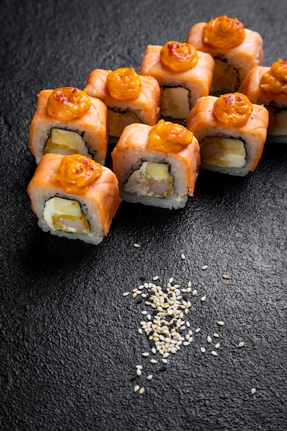 O prato de sushi japonês tradicional rola sushi em um fundo escuro