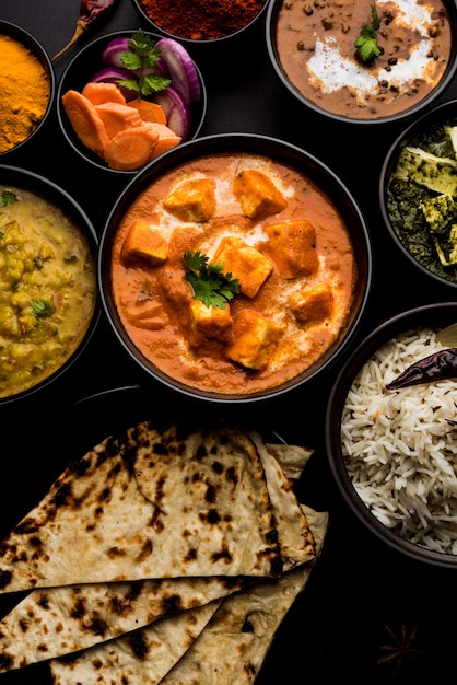 O prato principal do almoço ou jantar indiano no grupo inclui Paneer Butter Masala, Dal Makhani, Palak Paneer, Roti, Arroz etc, Foco seletivo