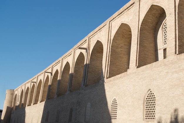 O prédio antigo, a parede com arcos. edifícios antigos da ásia medieval. bukhara, uzbequistão
