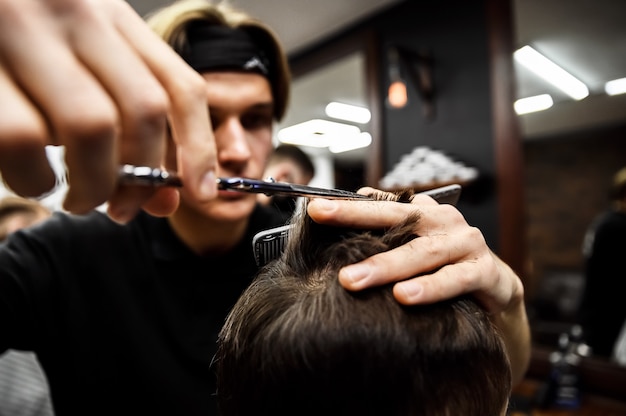 O processo de corte de cabelo masculino em uma barbearia estilosa