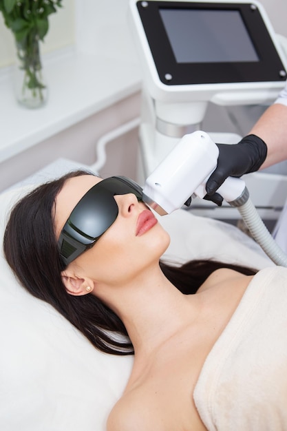 O processo de depilação a laser do corpo feminino cosmetologia profissional depilação do rosto e área do lábio superior Menina de óculos conceito de cuidado corporal