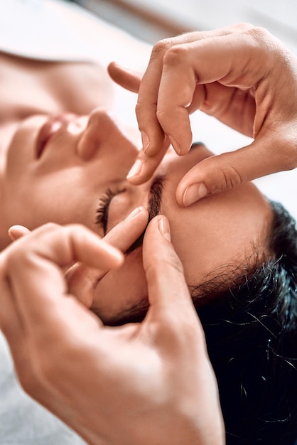 O processo de esculpir a massagem facial no escritório do cosmetologista