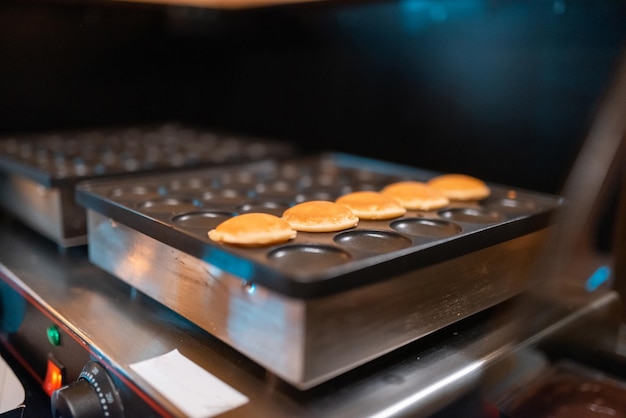 O processo de fazer poffertjes deliciosos e frescos Fazendo poffertjes frescos Tradicional guloseima holandesa Foco seletivo