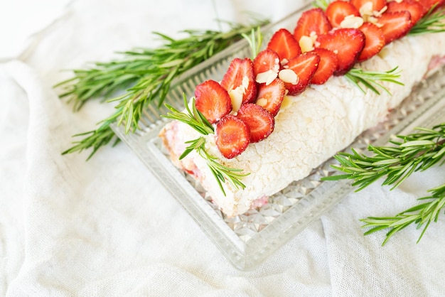 O processo de fazer um rolo de merengue Cozinhar um rolo de merengue na cozinha Rolo de merengue com morangos e decorado com alecrim