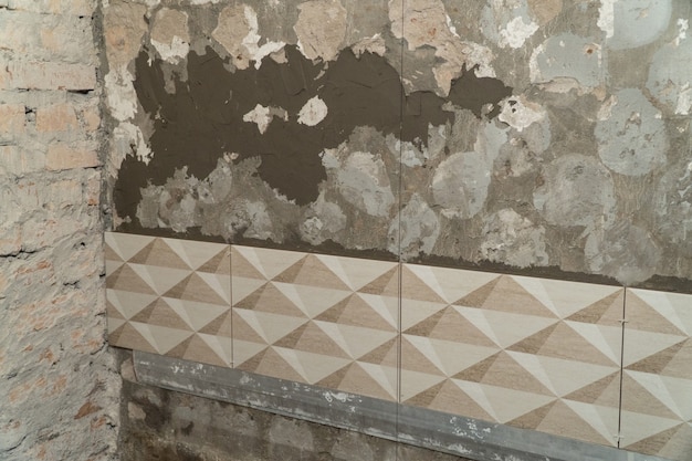 Foto o processo de instalação de azulejos decorativos na parede do banheiro