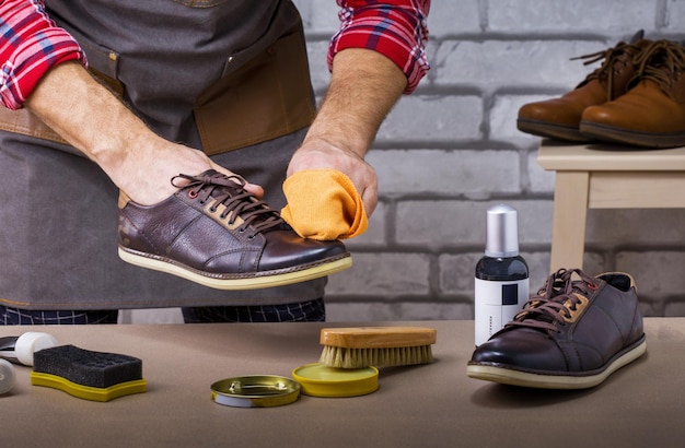 O processo de limpeza de sapatos. Homem engraxando sapatos em casa.
