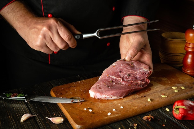 Foto o processo de preparação de um bife de carne pelas mãos de um chef em uma mesa de cozinha com especiarias aromáticas cozinhar suculento e saboroso shish kebab para o almoço