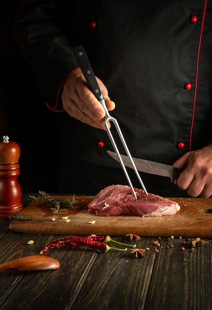 O processo de preparação de um bife de carne pelas mãos de um cozinheiro