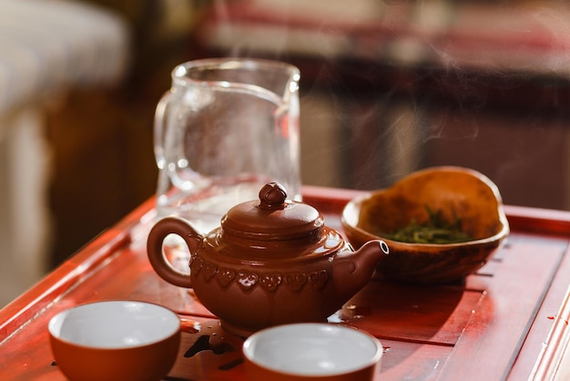 O processo de preparação do chá na cerimônia do chá. Natureza morta com um bule, duas xícaras e chahe.