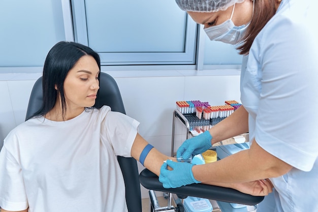 Foto o processo de tirar sangue das veias para análise