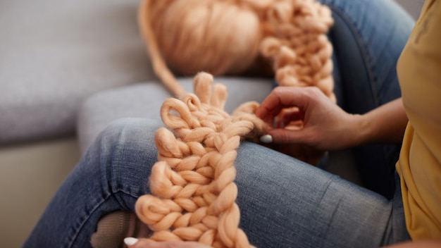 O processo de tricotar cobertores feitos de Merino. cobertor feito de lã de ovelha natural. close-up de fios de mão. casa produz xadrez artesanal. manta volumétrica de designer. malhas de tecelagem com as próprias mãos