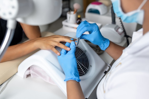 O processo de usar limas de unhas. O conceito de serviço de unhas