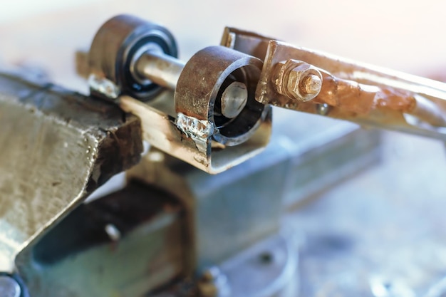 O produto de metal é espremido em um torno no local de trabalho na oficina