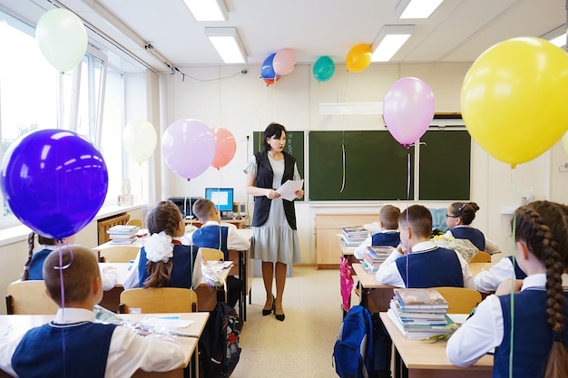 O professor diz as regras aos alunos, as crianças sentam-se às suas carteiras e ouvem com atenção.