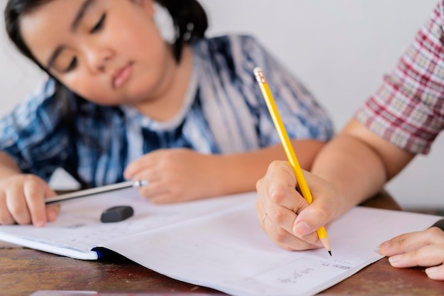 O professor está ensinando uma menina asiática Eles estão aprendendo matemática