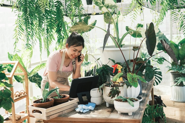 O proprietário da loja de plantas jovem está verificando o pedido do cliente no site