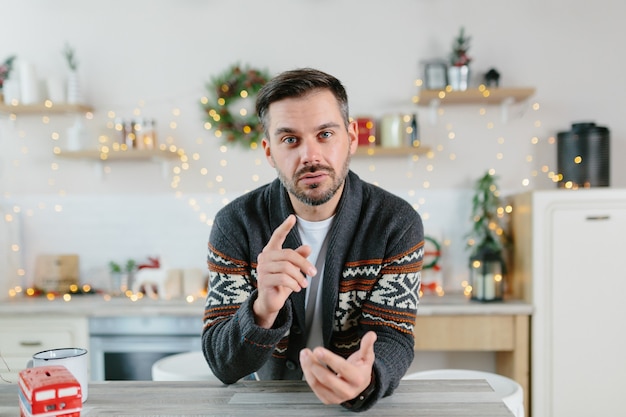 O próprio homem em casa olha para a câmera e se comunica via link de vídeo, visualização da webcam, cumprimenta amigos e colegas com feriados de Natal e Ano Novo