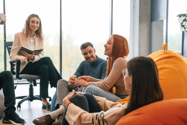 Foto o psicólogo está sentado e a ouvir um grupo de pessoas a ter uma reunião de terapia.