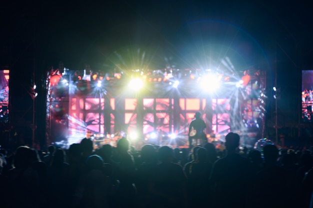 O público jovem de silhueta está assistindo o concerto noturno