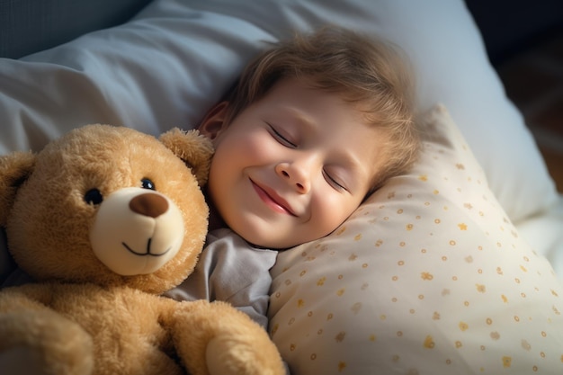 O rapaz dorme doce na cama com um urso de brinquedo nos braços debaixo do cobertor.