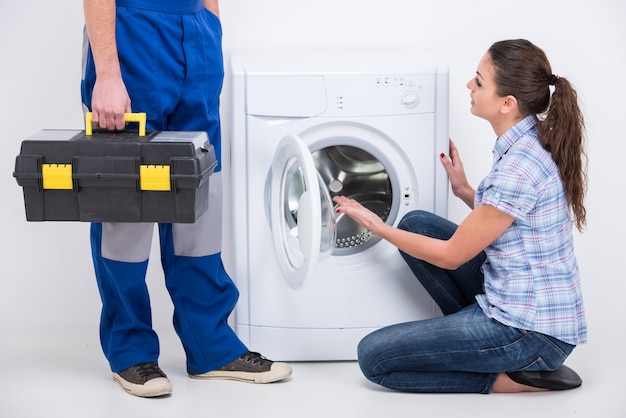 O reparador veio reparar uma máquina de lavar roupa.