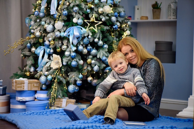 O retrato da mãe e do filho felizes comemoram o Natal. Feriados de Ano Novo