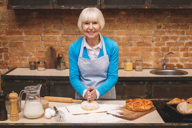 O retrato da mulher envelhecida atrativa sênior está cozinhando na cozinha