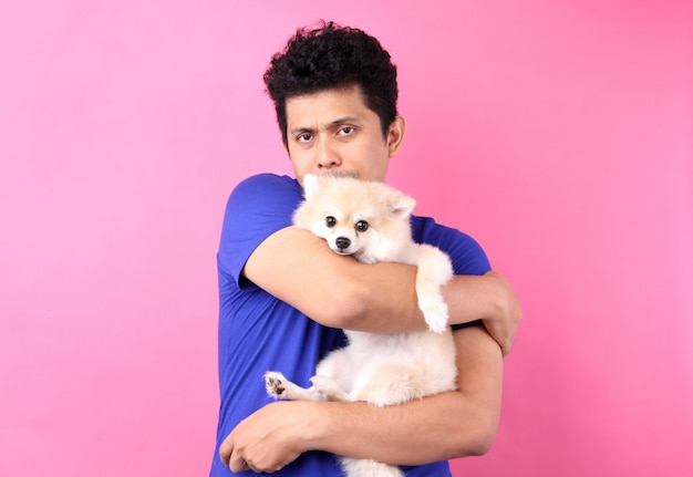 O retrato de homens asiáticos guarda o cão pomeranian com amor e