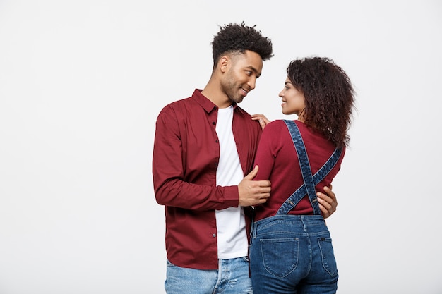 O retrato de pares afro-americanos felizes abraça-se no fundo branco.