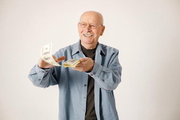 Foto o retrato de um ancião joga as notas isoladas sobre o fundo branco