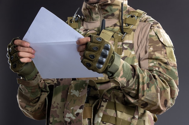 O retrato de um jovem soldado camuflado recebeu uma carta