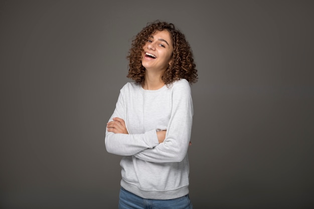 O retrato de uma jovem mulher indiana de sorriso no preto isolou o fundo no estúdio. Feliz garota afro-americana.