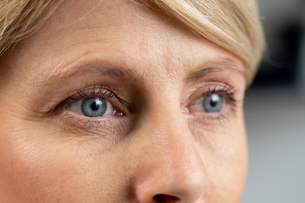 O retrato de uma mulher de meia idade olha para a distância, close-up dos olhos azuis de uma mulher