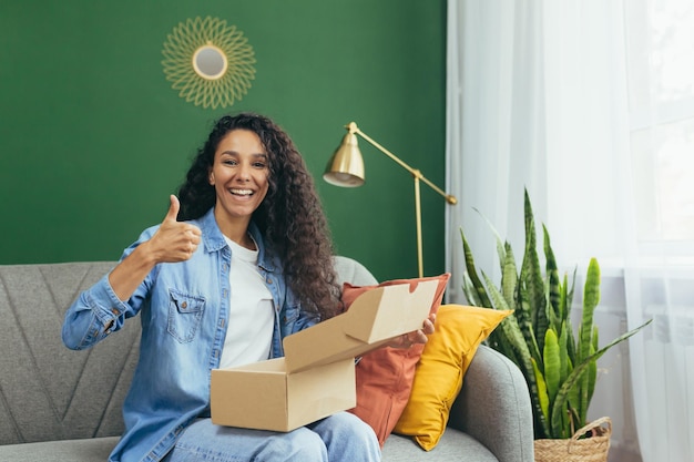 Foto o retrato de uma mulher latino-americana feliz e satisfeita em casa compradora recebeu uma caixa de encomendas de um