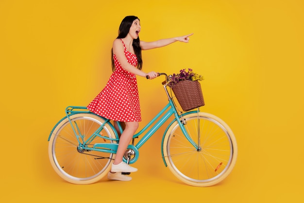 O retrato do perfil de uma bicicleta feminina indica o espaço vazio dos dedos, use tênis vermelho curto sobre fundo amarelo