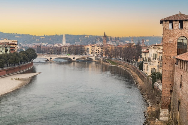 Foto o rio adige e o panorama de verona visto da ponte de castelvecchio ao pôr-do-sol