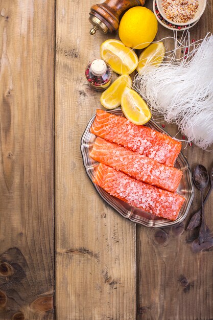 O salmão é fatiado e polvilhado com sal e especiarias, numa tábua de madeira