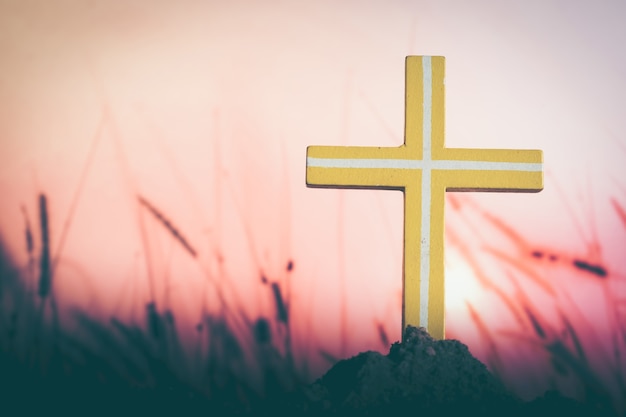 O símbolo cruzado do amor de Deus para as pessoas Silhouette a cruz sobre um fundo do pôr-do-sol