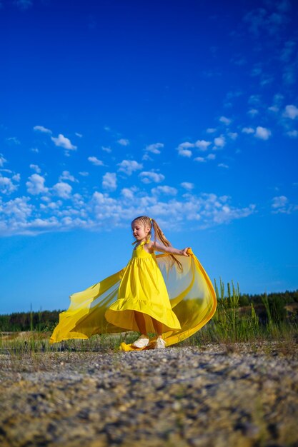 O símbolo da liberdade é uma menina ucraniana de 7 anos patrioticamente vestida com um vestido amarelo contra um céu azul céu azul dia ensolarado criança ucraniana livre símbolo infantil da ucrânia