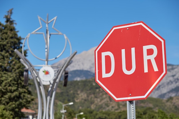 O sinal de estrada STOP em turco DUR é proibido na Turquia em frente às montanhas Foto de alta qualidade