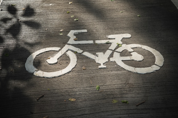 O sinal de maneira de bicicleta no chão de concreto