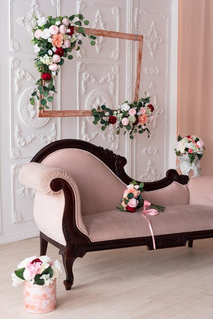O sofá esculpido é decorado com flores Interior para um tema de primavera de estúdio fotográfico